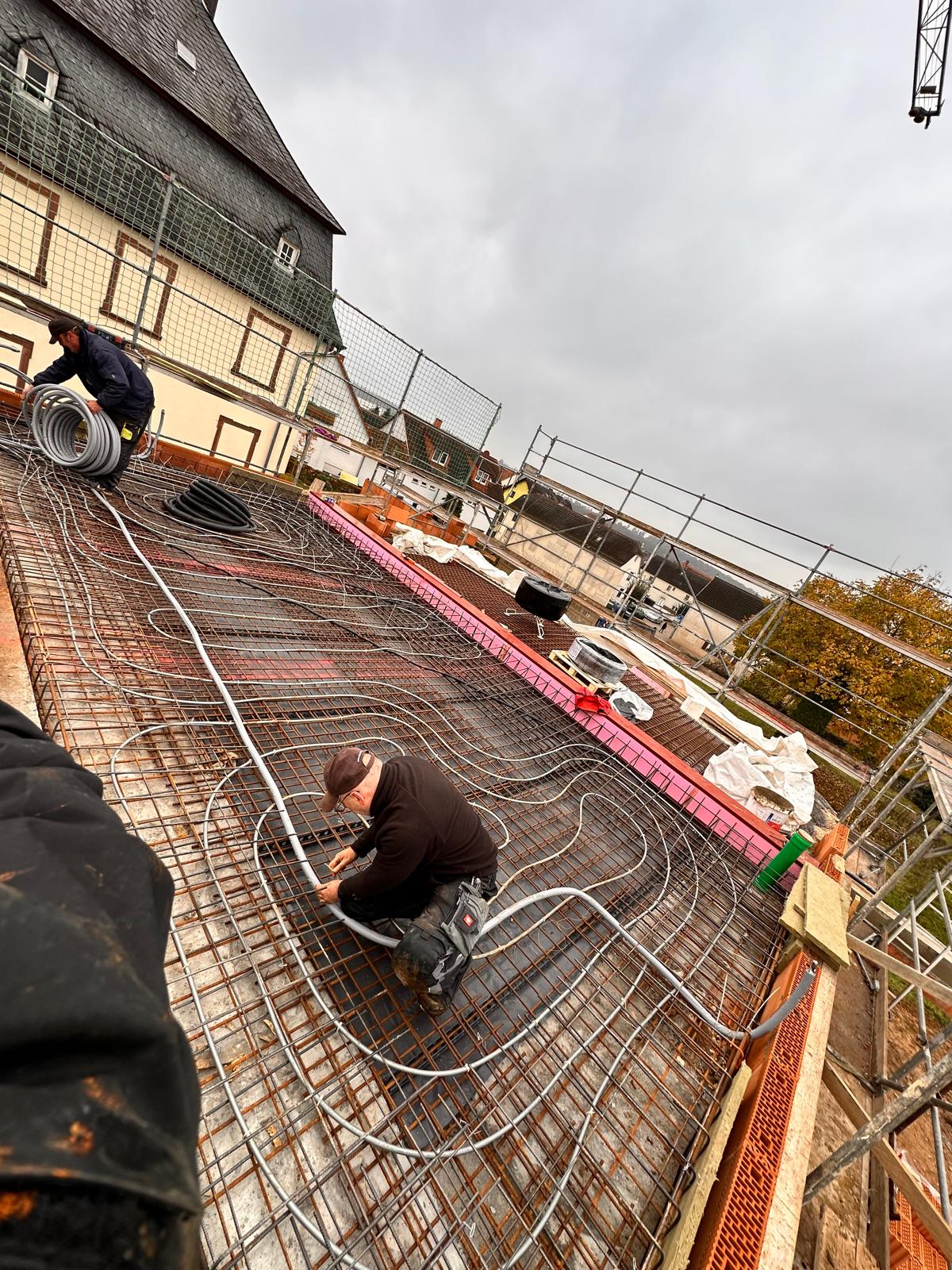 Mitarbeiter verlegen Rohre der Betonkernaktivierung in der Bewehrung einer Geschossdecke